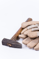 Old dirty hammer with used working leather gloves