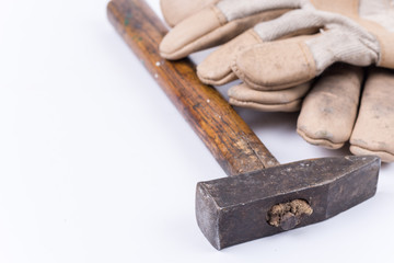 Old dirty hammer with used working leather gloves