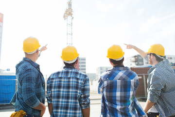 group of builders in hardhats at construction site