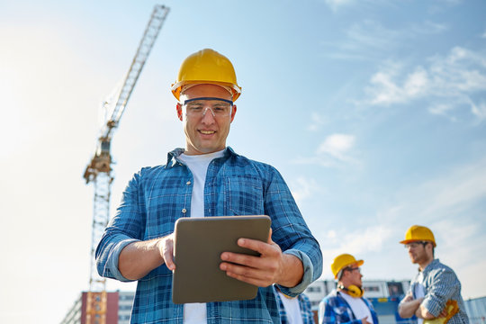 builder in hardhat with tablet pc at construction