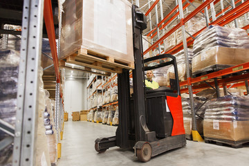 man on forklift loading cargo at warehouse