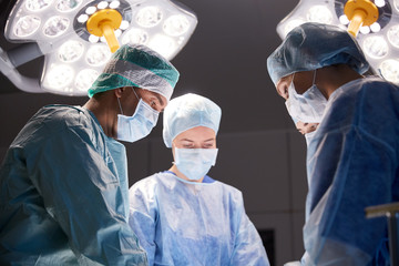group of surgeons in operating room at hospital