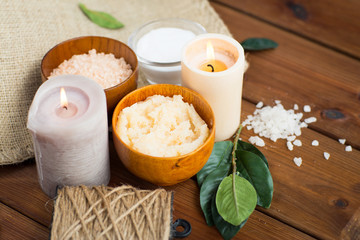 close up of natural body scrub and candles on wood