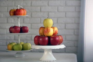 Ripe apples on stand on kitchen table