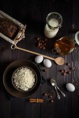 cottage cheese in a brown bowl on a dark wooden background