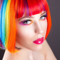 Fototapeta premium beautiful woman wearing colorful wig and showing colorful nails