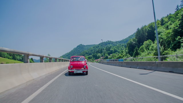 Red zastava car driving and a blue car passes him