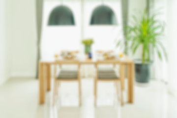Fototapeta na wymiar blurred dining table and chairs with elegant table setting for background