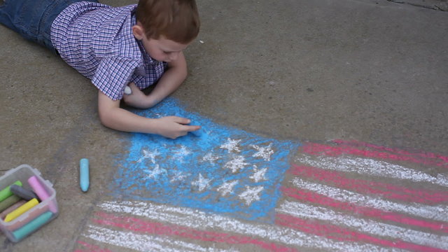 Boy coloring American flag with chalk
