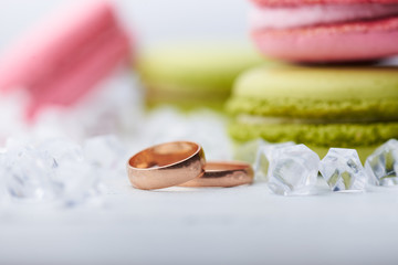 Two wedding rings and sweet macaroons