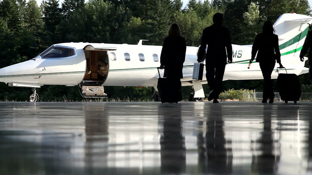 Businesspeople walking out to jet