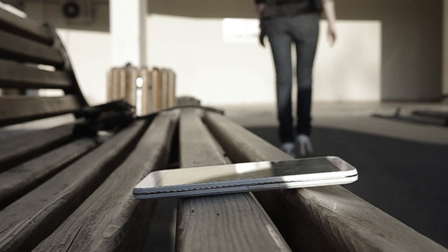 A young girl forgets her smartphone on bench