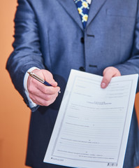 Businessman handing over the contract and a pen to sign