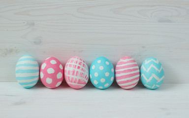 Pink and blue easter eggs on a wooden background