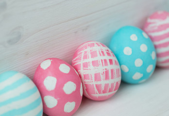 Pink and blue easter eggs on a wooden background