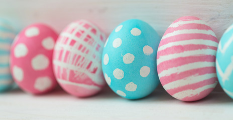 Pink and blue easter eggs on a wooden background