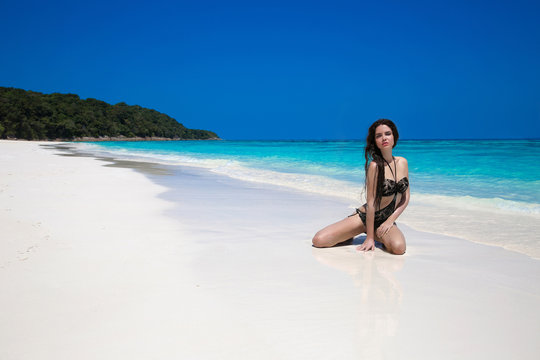 Beautiful sexy bikini model woman posing relaxing on exotic trop