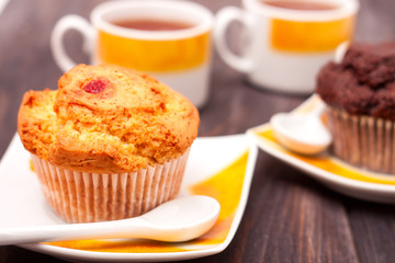 Cupcakes with tea on black wooden background