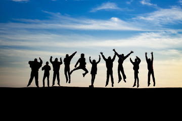 group of young people is jumping on top of the mountain