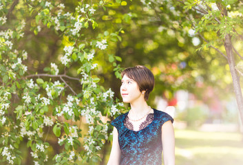 Beautiful young asian woman in flowering spring garden. 