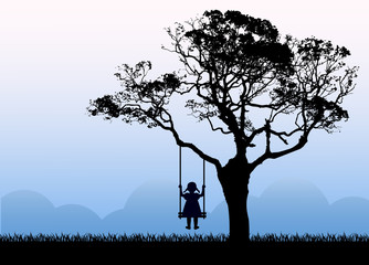 Child silhouette sitting on a swing. Swing hanging from a tree. The tree grows on a meadow next to the mountains