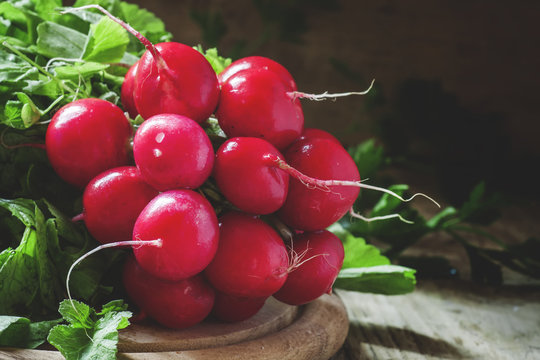 bunch of red radishes on a cutting board, selective focus