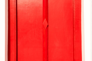 red wood door on white wall