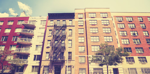 Vintage toned photo of New York building with fire escape ladder.