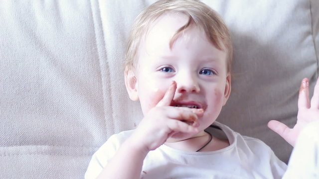 Little Boy Eating Chocolate And Smeared Mouth