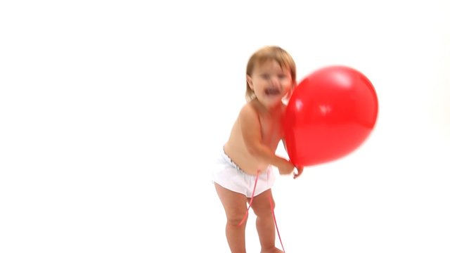 Baby playing with red balloon on white background