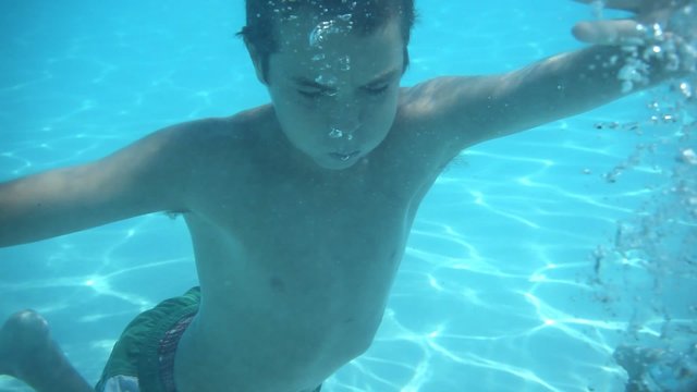 Two kids swimming underwater