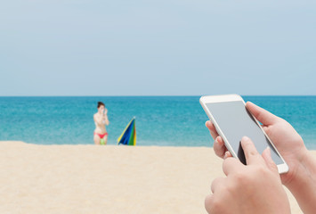 Women using smartphone top on blurred blue sea