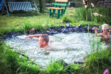 In the summer, bright sunny day, happy family is bathed dives, into the pond. Water splashes