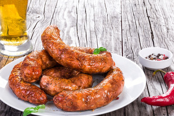 grilled sausages are on a white dish, top view