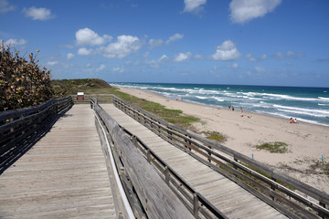 Fototapeta na wymiar Old wooden boardwalk provides handicapped access to the beach at John D MacArthur State Park near West Palm Beach, Florida.