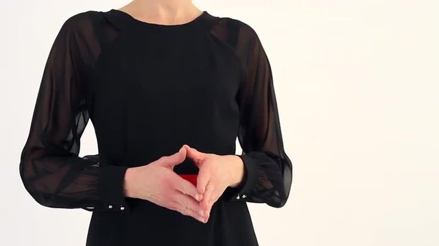 A Woman Has Doubts/Beautiful woman reacts to someone's words. She gesticulates while talking. She in black dress with a red strap. Her posture it shows distrust, doubt