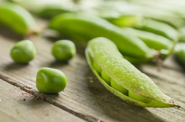 Raw peas on wooden table close up