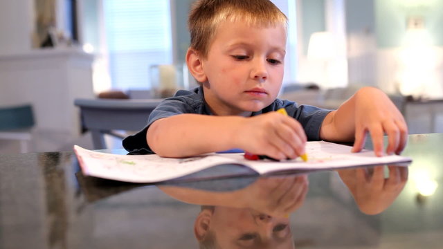Young boy coloring with crayons