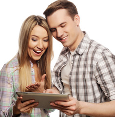 happy young couple holding tablet pc computer 