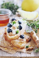 Sandwich with cottage cheese, blueberries,walnuts and honey. Toned image.Selective focus 