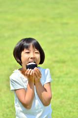 Fototapeta premium おにぎりを食べる女の子