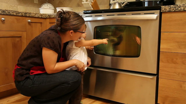 Mother and daughter looking at turkey in oven