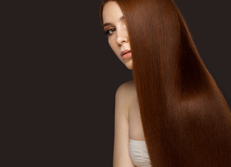 Beautiful Redheadgirl with a perfectly smooth hair and classic make-up. Beauty face. 