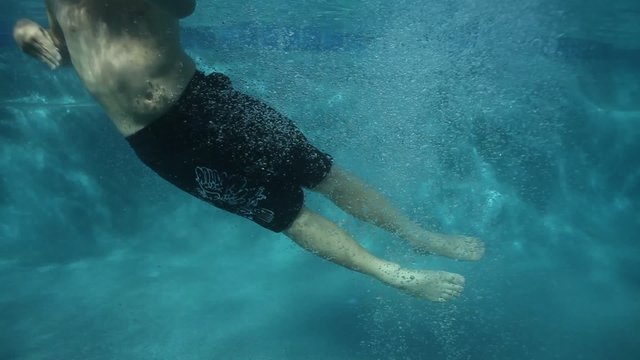 Boy jumps into pool, underwater shot