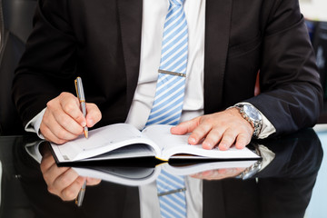 Businessman checking up a diary
