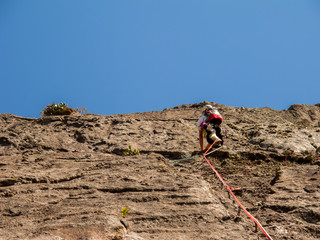 Rock climber climbing a sloping rock wall in Brazil