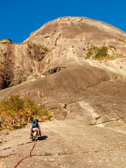 Fototapeta premium Rock climber climbing a sloping rock wall in Brazil