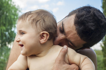 Father holding and kissing his little baby.