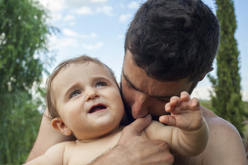 Father holding and kissing his little baby.