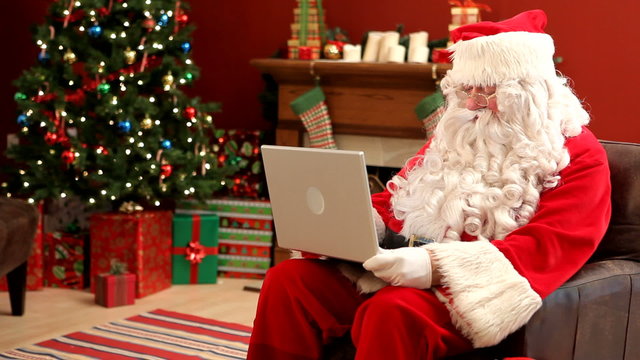 Santa Claus working on laptop computer